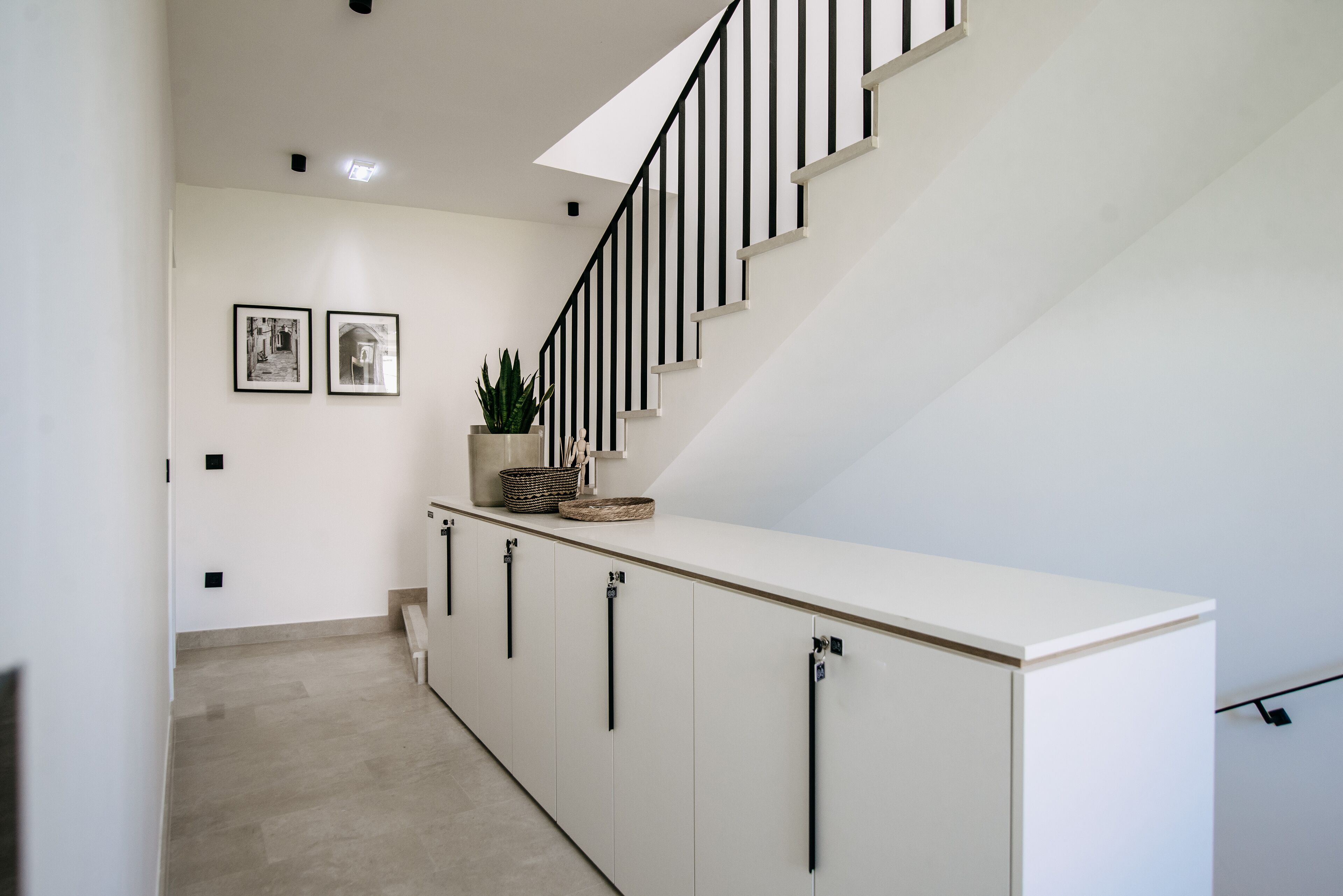 A modern staircase with black railings and a white landing area.