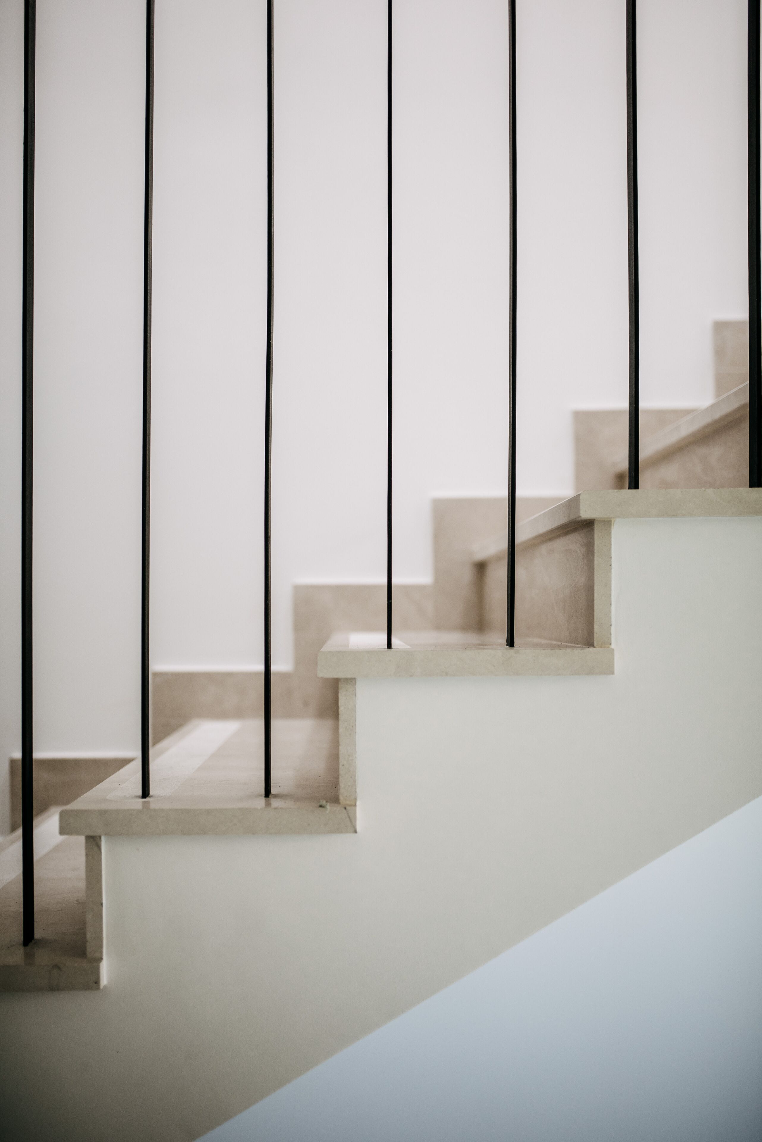 A staircase with a minimalist design, featuring a light-colored wall and a simple, clean aesthetic.