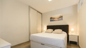 Ein ordentlich eingerichtetes Schlafzimmer mit einem Bett, Nachttischen und einem Bild an der Wand.