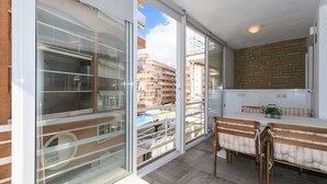 Ein Balkon mit Blick auf einen Swimmingpool und angrenzende Gebäude.