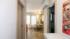 Eine moderne Küche mit Essbereich, einem roten Stuhl und einem großen Fenster mit Vorhängen.