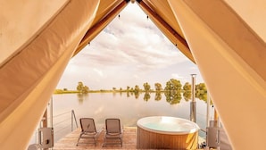 A tented area with a hot tub and two chairs facing a calm lake. - Laghi Nabi (Castel Volturno)