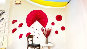 A room with a geometric patterned floor, a round table with a chair, a wall-mounted fan, and a vase with red berries. - Mon Bac Home (Lam Vien - Da Lat)