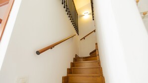 A wooden staircase with a handrail and a light fixture above. - La terrazza di Giulietta (San Giovanni Lupatoto)