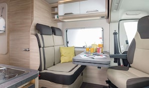 Enjoy a compact kitchenette, dining area, and cozy seating space within this motorhome.