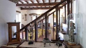 A wooden staircase with a glass enclosure at the top, leading to a room with a chandelier and a statue. - Vacation home Virgo by Interhome (Cortona)