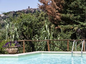 A swimming pool with a view of a hillside town.