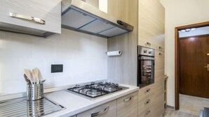 Une cuisine moderne équipée d’une cuisinière à gaz, d’un four et de meubles en acier inoxydable.
