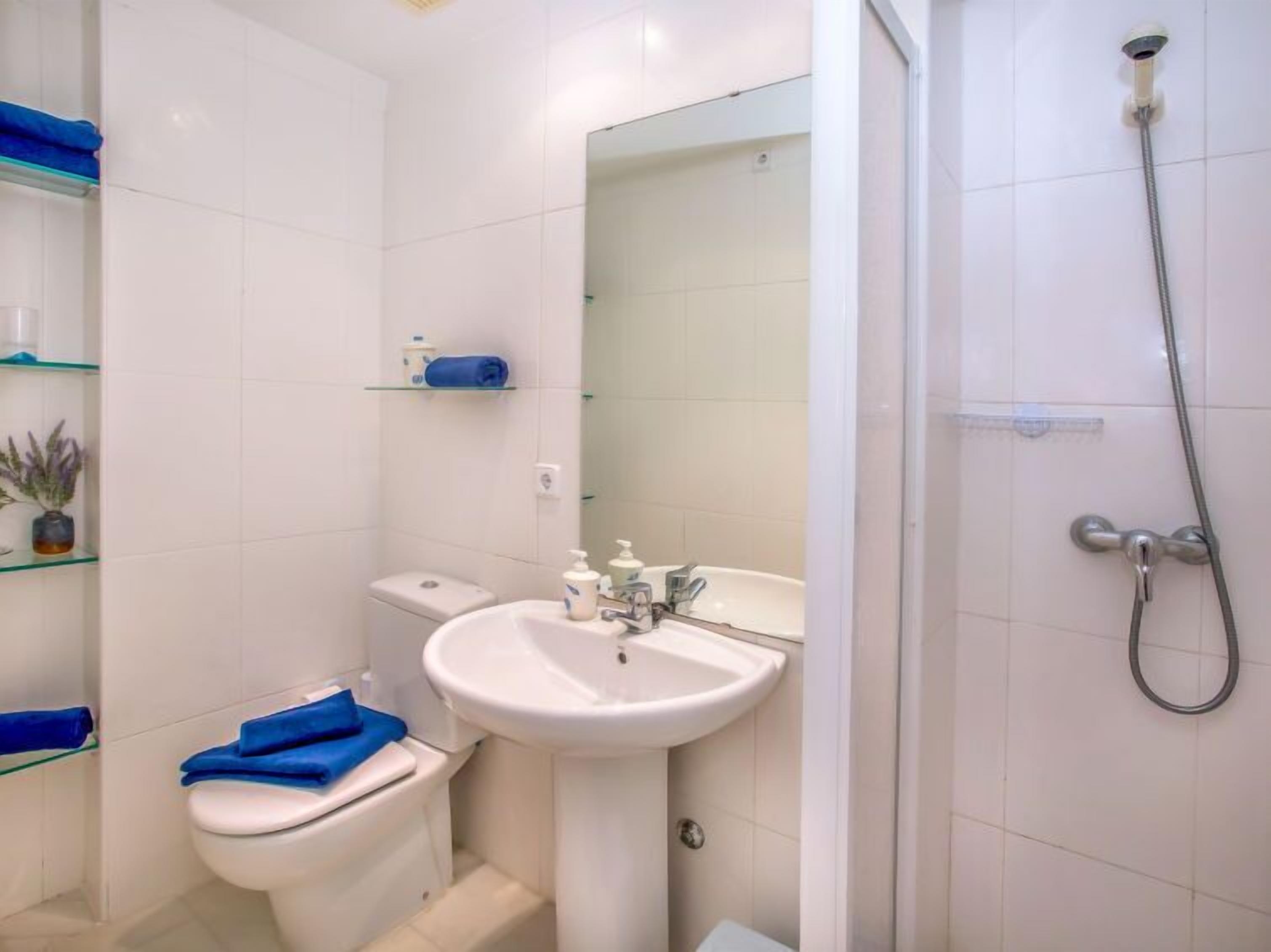 Une salle de bain avec des toilettes, un lavabo et une douche.