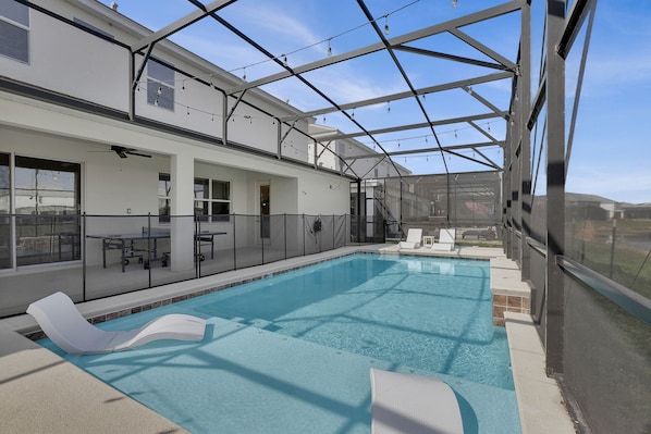 An indoor swimming pool with a glass ceiling, lounge chairs, and a table with chairs. - 🏰✨ Luxurious 15BR Mansion with Lake Views near Disney! 🌊🌟 (Kissimmee)