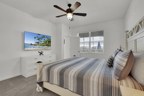 A bedroom with a bed, a ceiling fan, a window with blinds, a TV on the wall, and a dresser. - 🏰✨ Luxurious 15BR Mansion with Lake Views near Disney! 🌊🌟 (Kissimmee)