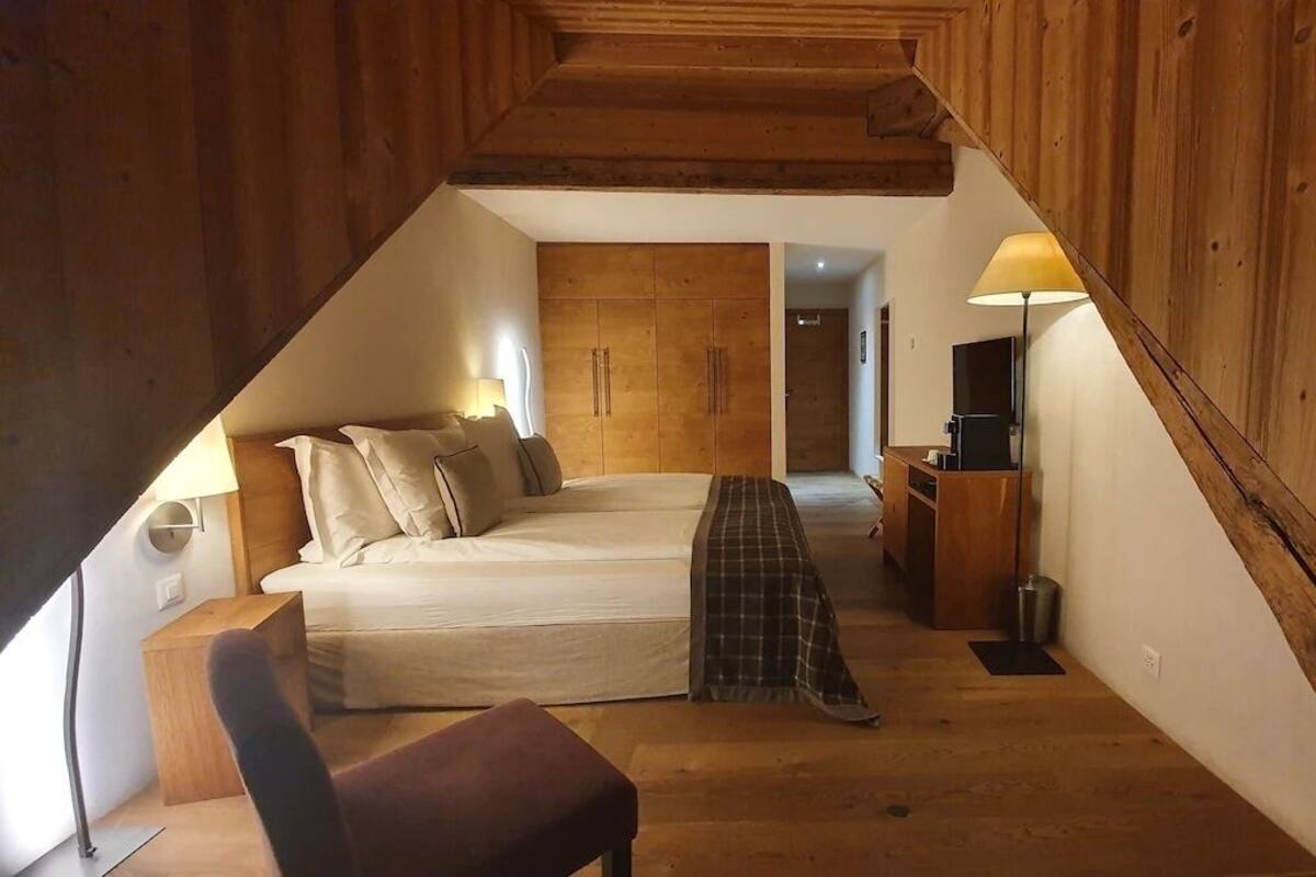 Ein Schlafzimmer mit Bett, Nachttisch, Lampe und Fernseher.