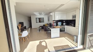 Een modern appartement met keuken, eethoek en zithoek.