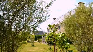 Une maison avec une pelouse bien entretenue, un mur en briques et un jardin.