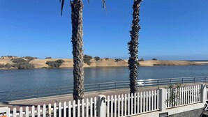 A view of a river with palm trees and a white picket fence in the foreground. - Apartamento Maypa 1 Calma (Maspalomas)