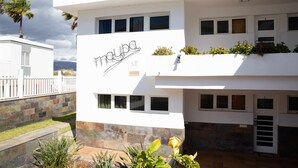 A modern building with a white facade, multiple windows, and a sign that reads "MAYUBA". - Apartamento Maypa 1 Calma (Maspalomas)