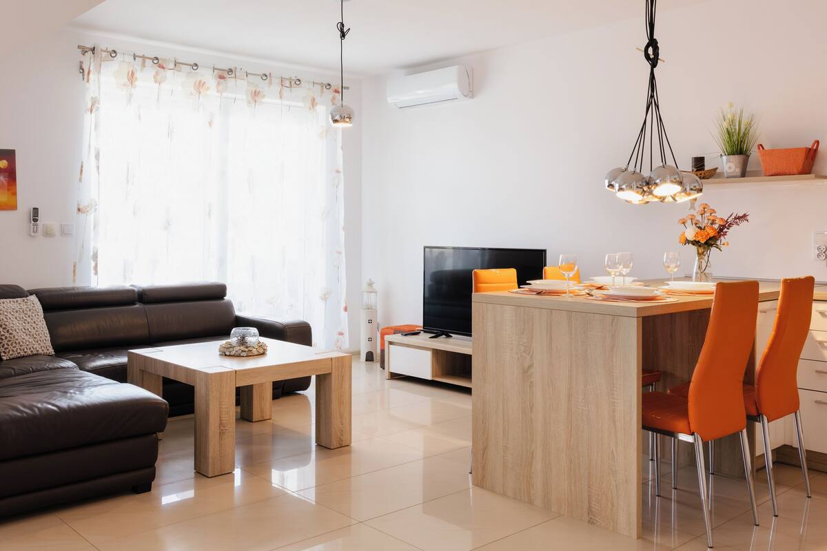 Una sala de estar moderna con un sofá, una mesa de centro y un comedor con sillas y una mesa.