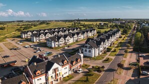 Zona residencial con casas modernas, un estacionamiento y una calle.