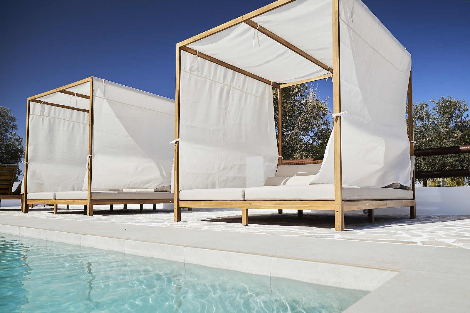 Una piscina al aire libre, tumbonas