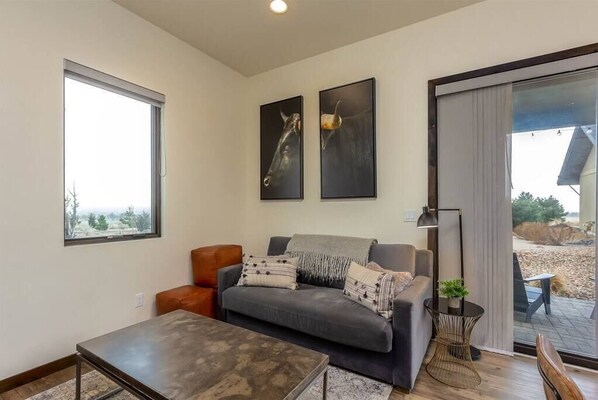 Relax in this stylish living room with a sofa, coffee table, and floor lamp, plus a sliding door to an outdoor patio.