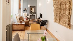 A modern living room with a dining area, featuring a sofa, chairs, a coffee table, and a rug. - Central Apartment 2BR/2BA | Balcony | Lift in Baixa (Lisboa ciudad)