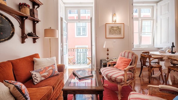 A cozy living room with a sofa, armchairs, a coffee table, and a dining area with a table and chairs. - Central 2BR/2BA Apartment Balcony Elevator in Baixa (Lisboa ciudad)