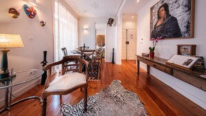A spacious living room with wooden flooring, a zebra rug, a dining area with chairs and a table, a sofa, and a painting on the wall. - Baixa Apartment 2BR|2BA with Balcony, Lift (Lisboa ciudad)