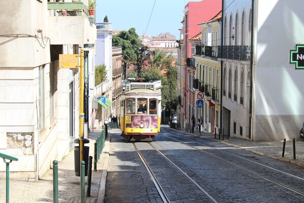 Un tramway circule sur une rue pavée, dans le centre historique d’une ville.