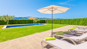 A poolside area with lounge chairs, a pool, and a view of mountains. - ES MUSSOL - Villa with private pool in SA POBLA. Free WiFi (Sa Pobla)