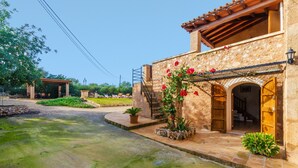 Un edificio in pietra con una porta in legno e un portico coperto.