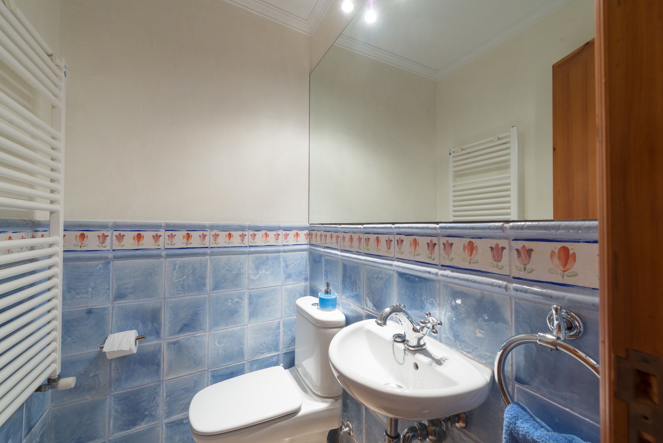 Un bagno con il water, un lavandino e uno specchio.