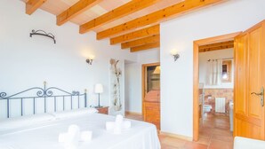 Une chambre à coucher avec un lit, des lampes de chevet et un plafond en bois.