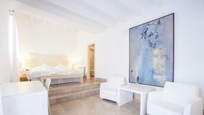 A modern hotel room with a large bed, white furniture, and a large abstract painting on the wall. - SON SIMÓ VELL - Villa with private pool in Alcúdia. (Alcúdia)
