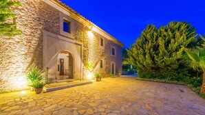 A stone building with a paved entrance, potted plants, and a large tree. - SON SIMÓ VELL - Villa with private pool in Alcúdia. (Alcúdia)