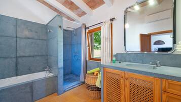 Een badkamer met een bad, douche en wastafel.