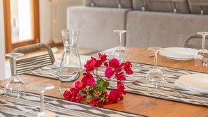 A dining table set with clear glassware and a centerpiece of red flowers. - FETGET-CAN BOSCO - Nice country house with private pool close to the beach. Free WiFi (Son Servera)