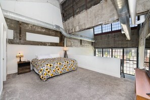 A bedroom with a bed, a nightstand, a lamp, and a window with a view. - 5102 Peters · Large loft near Kings Island. On bike trail/River. (Maineville)