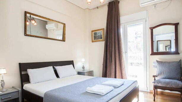 A neatly arranged bedroom with a large bed, a chair, and two bedside tables.