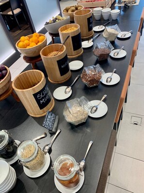 A buffet setup with various food items and utensils. - IIP Apartments - Self Check In (Spreitenbach)