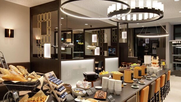 A buffet setup with various food items and a modern interior design. - IIP Apartments - Self Check In (Spreitenbach)