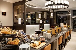 A buffet setup with various food items and a modern interior design. - IIP Apartments - Self Check In (Spreitenbach)
