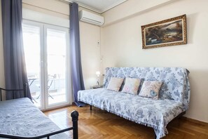 A room with a sofa, a table, and a painting on the wall. - Fabulous apartment at Exarcheia (Athens)