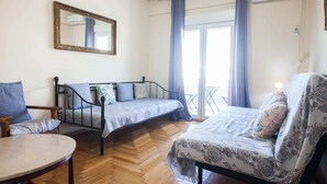A room with two beds, a chair, a table, and a mirror. - Fabulous apartment at Exarcheia (Athens)