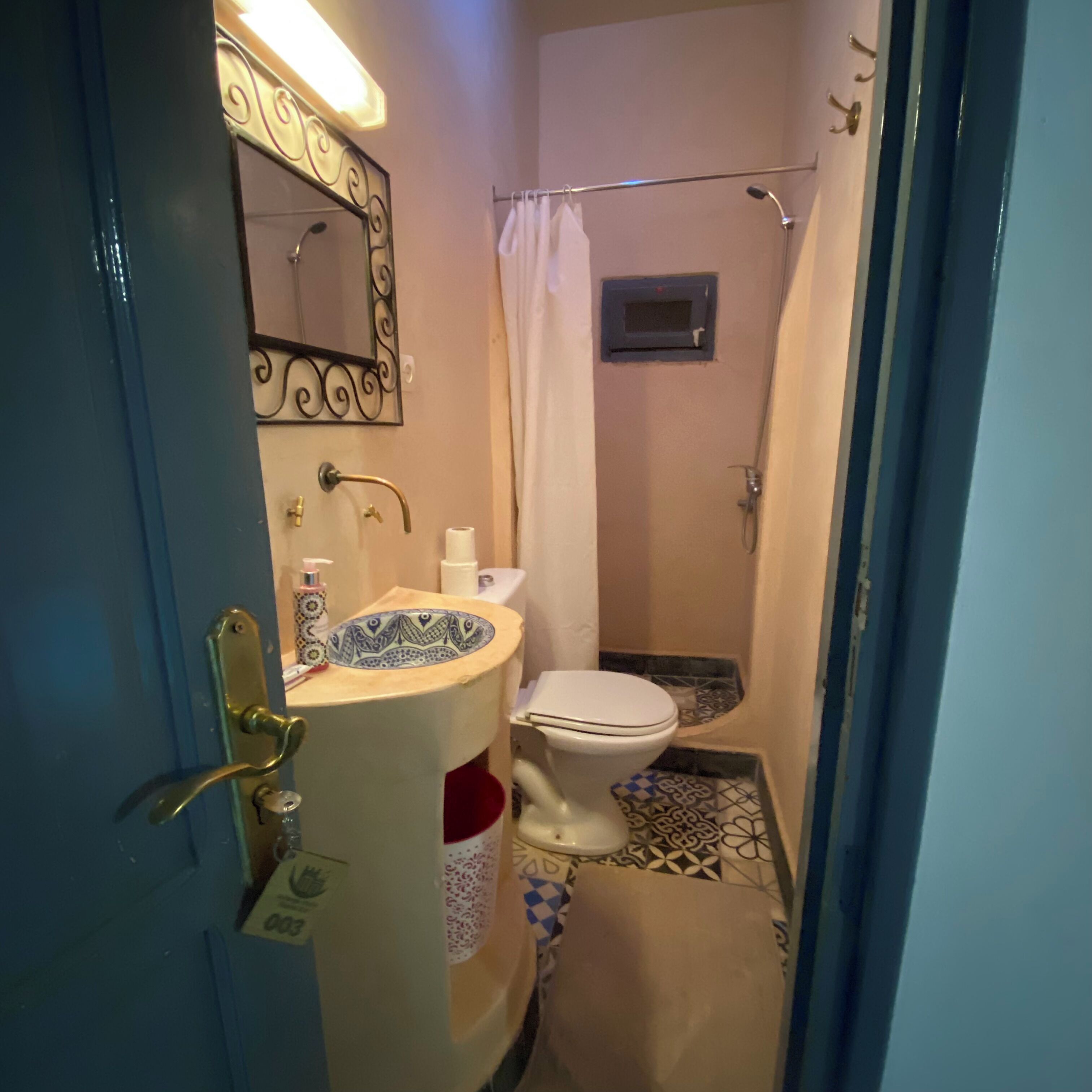 A small bathroom with a toilet, sink, and shower.