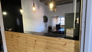 Ein Empfangsbereich mit Holztresen, hängenden Pendelleuchten und einem gemusterten Boden.
