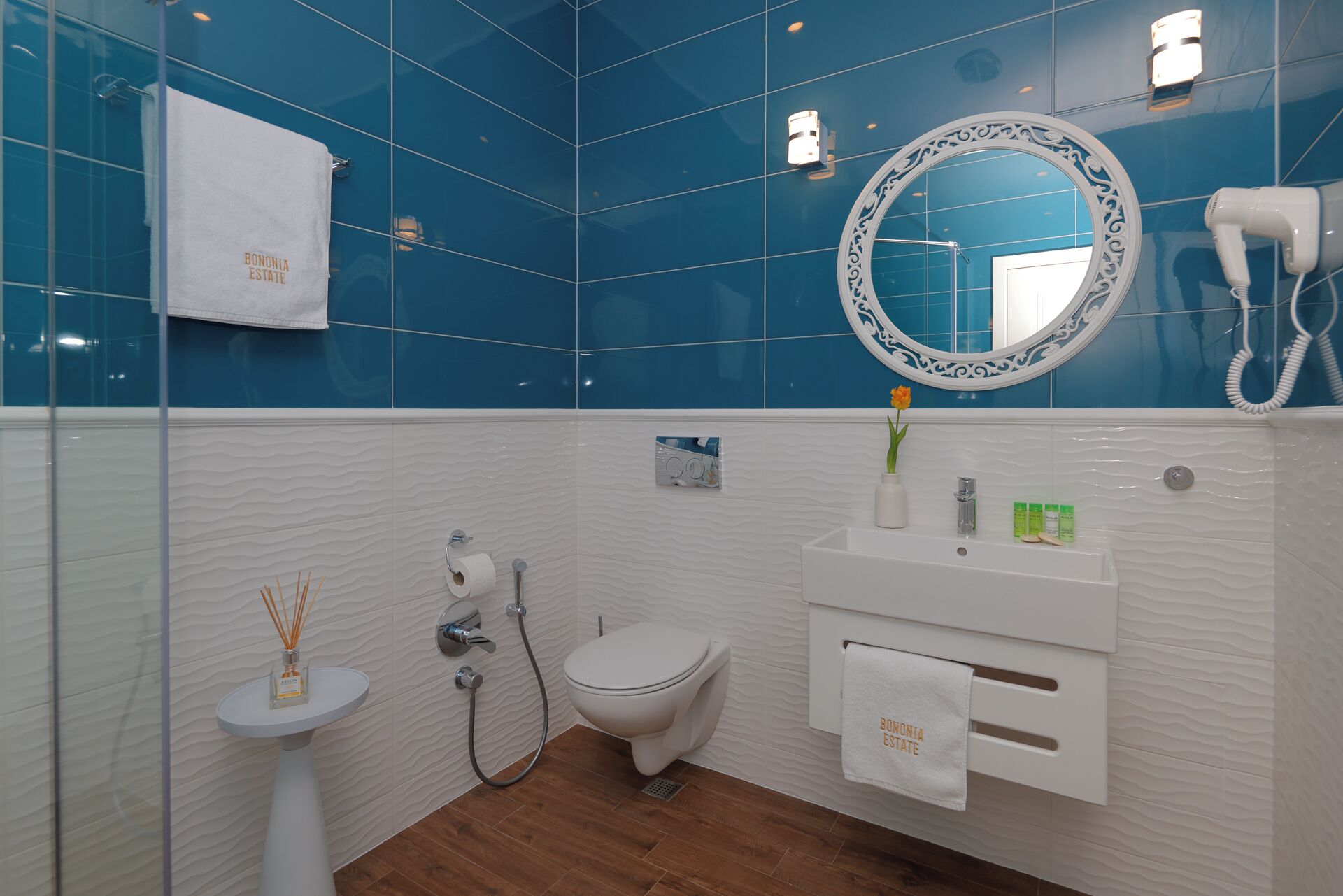 A bathroom with a white sink, a toilet, a mirror, and a towel rack.