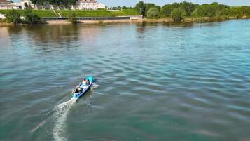 Un río tranquilo con una embarcación azul dejando una estela.