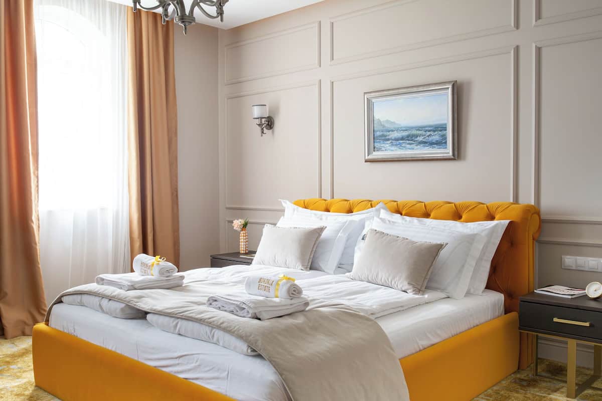 Une chambre d’hôtel avec un grand lit, une table de chevet, une lampe et un tableau au mur.