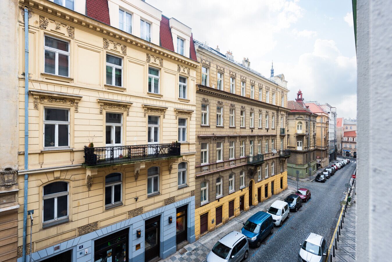 Eine Reihe mehrstöckiger Gebäude mit Balkonen und einer Kopfsteinpflasterstraße.