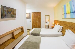 A hotel room with two beds, a wooden bench, a TV, and a painting. - Pousada SunBrazil (Jijoca de Jericoacoara)